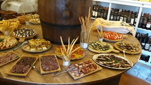 Diversos platos de comida y una torre con botellas de vino.