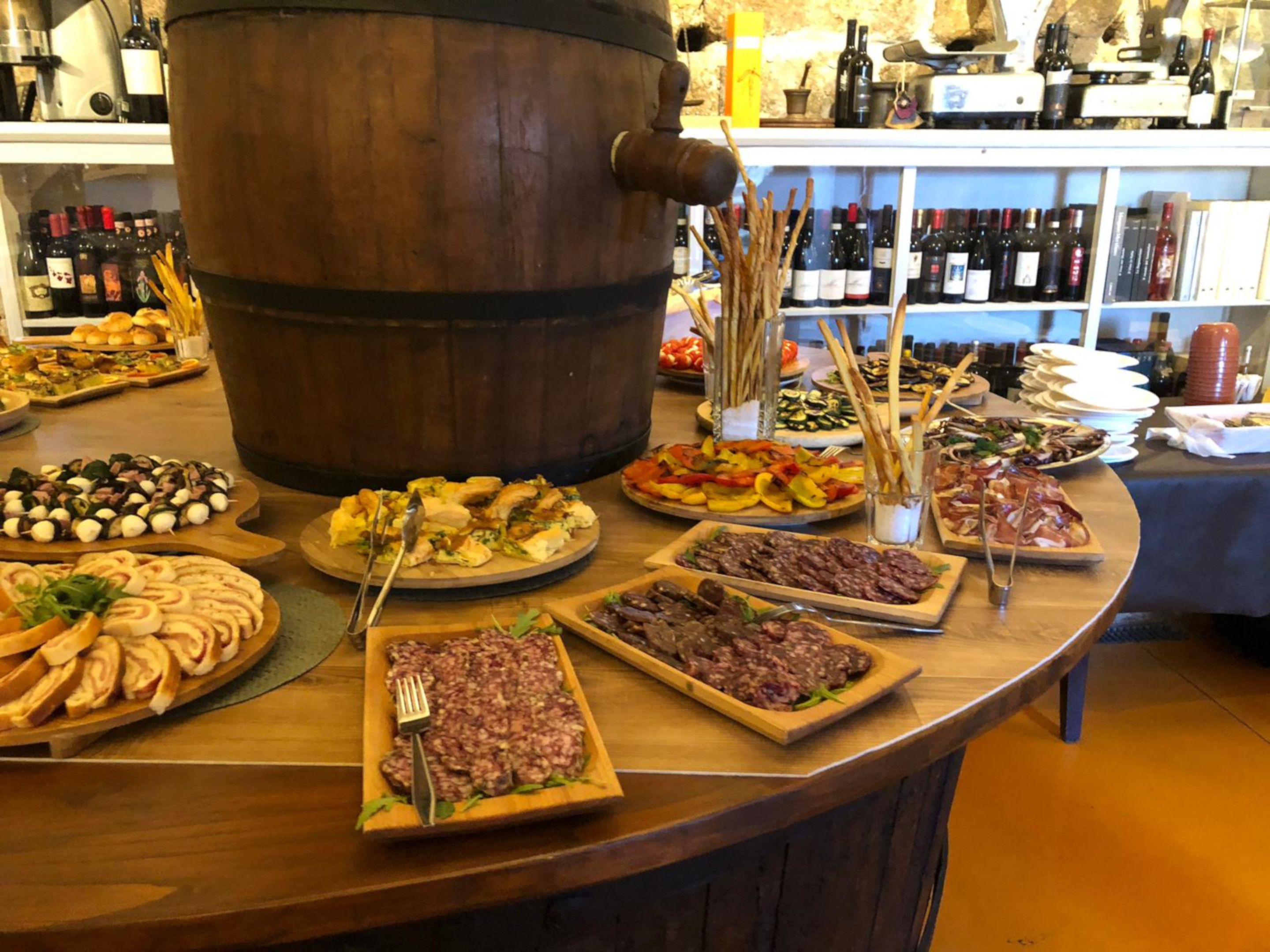 Un buffet proposant une variété de plats, avec un grand tonneau en bois en arrière-plan.