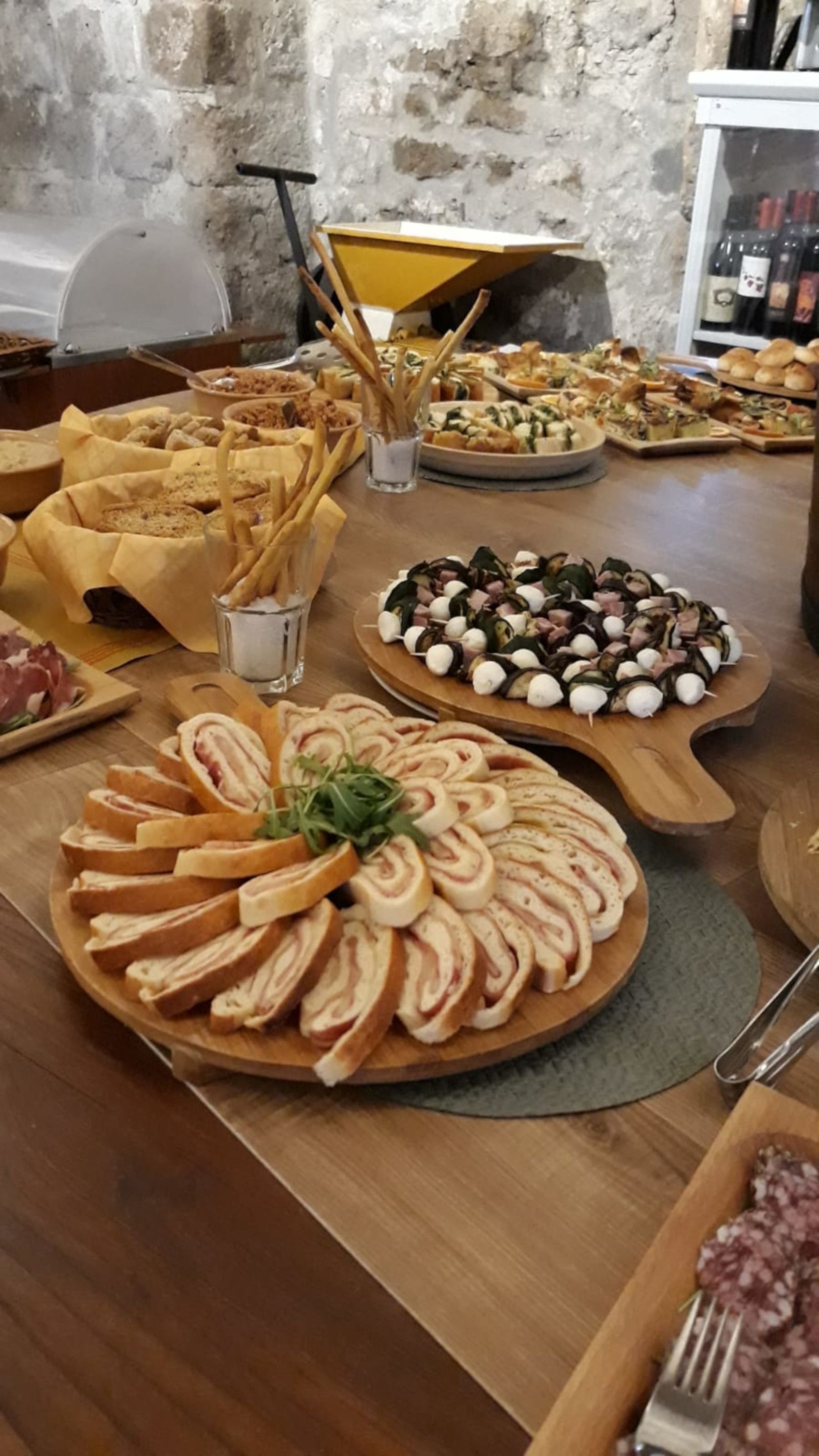 Una mesa de buffet con diversos alimentos, como pan en rebanadas, queso y carne.