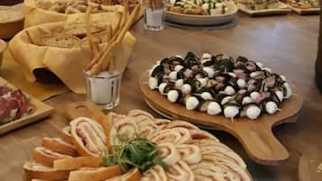 Una mesa de buffet con diversos alimentos, como pan en rebanadas, queso y carne.