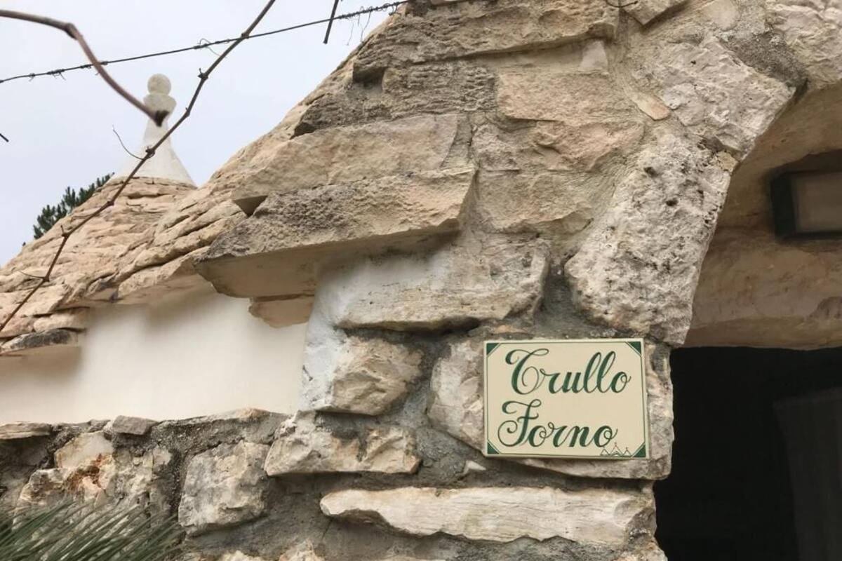 Un muro de piedra con un cartel que dice 'Trullo Forno'.
