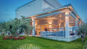 A modern house with a covered outdoor area, a lawn, and a large plant. - Gava Waterman Milna Resort (Milna)