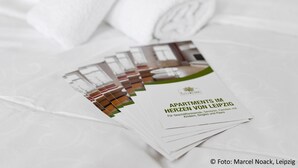Une brochure intitulée « Appartements à Leipzig », avec une photo de l’intérieur d’un appartement moderne.