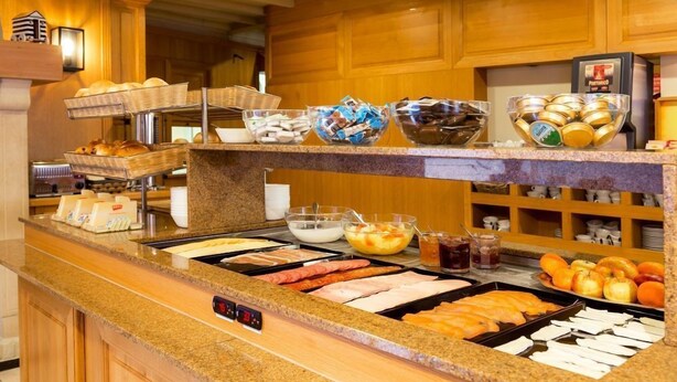 A buffet with various food items including meats, fruits, and condiments. - Hotel Franky (Blankenberge)