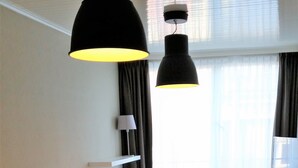 A hotel room with two beds, a desk, a chair, and a large window with curtains. - Hotel Franky (Blankenberge)