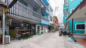 A street view of a building with a restaurant named "Hip Hostel" offering mixed dorms and double rooms. - Hip Hostel (Patong)