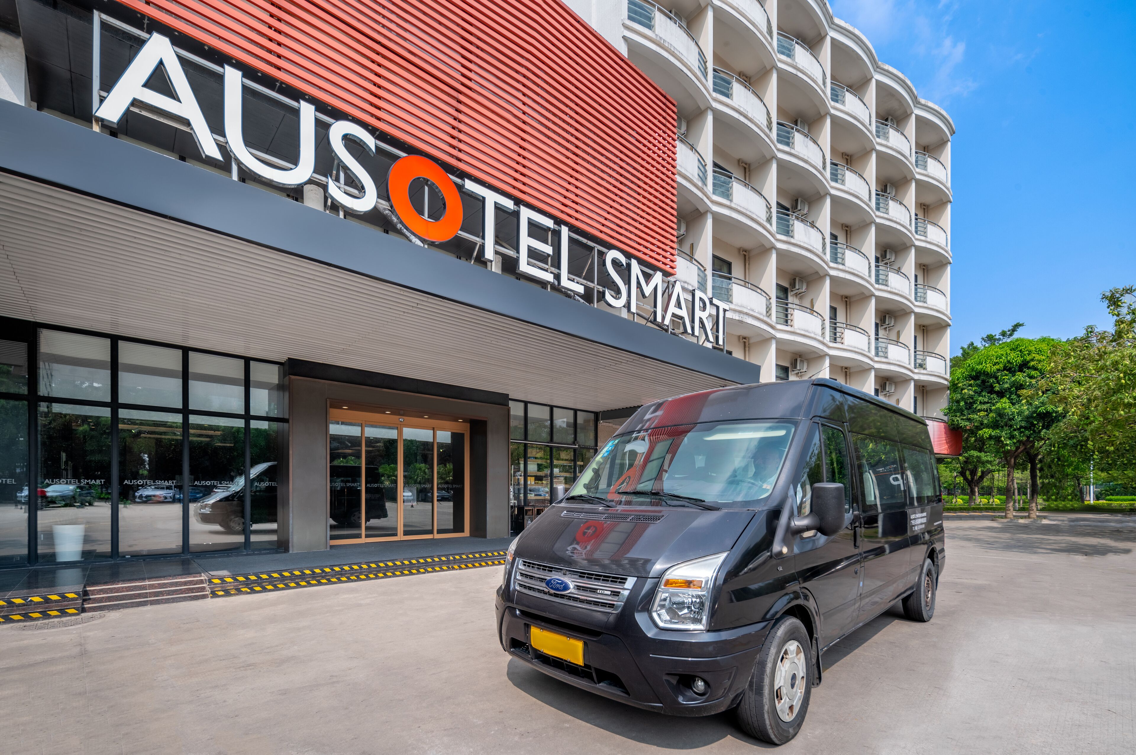 Un moderno edificio de hotel con un letrero llamativo que dice 'AUSotel Smart'.