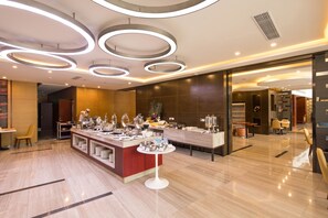 A modern hotel lobby with a central reception desk, a buffet area, and a seating area with chairs. - Ausotel Select Guangzhou Baiyun International Airport - Canton Fair courtesy shuttle bus from October 14 to November 4 (Guangzhou)