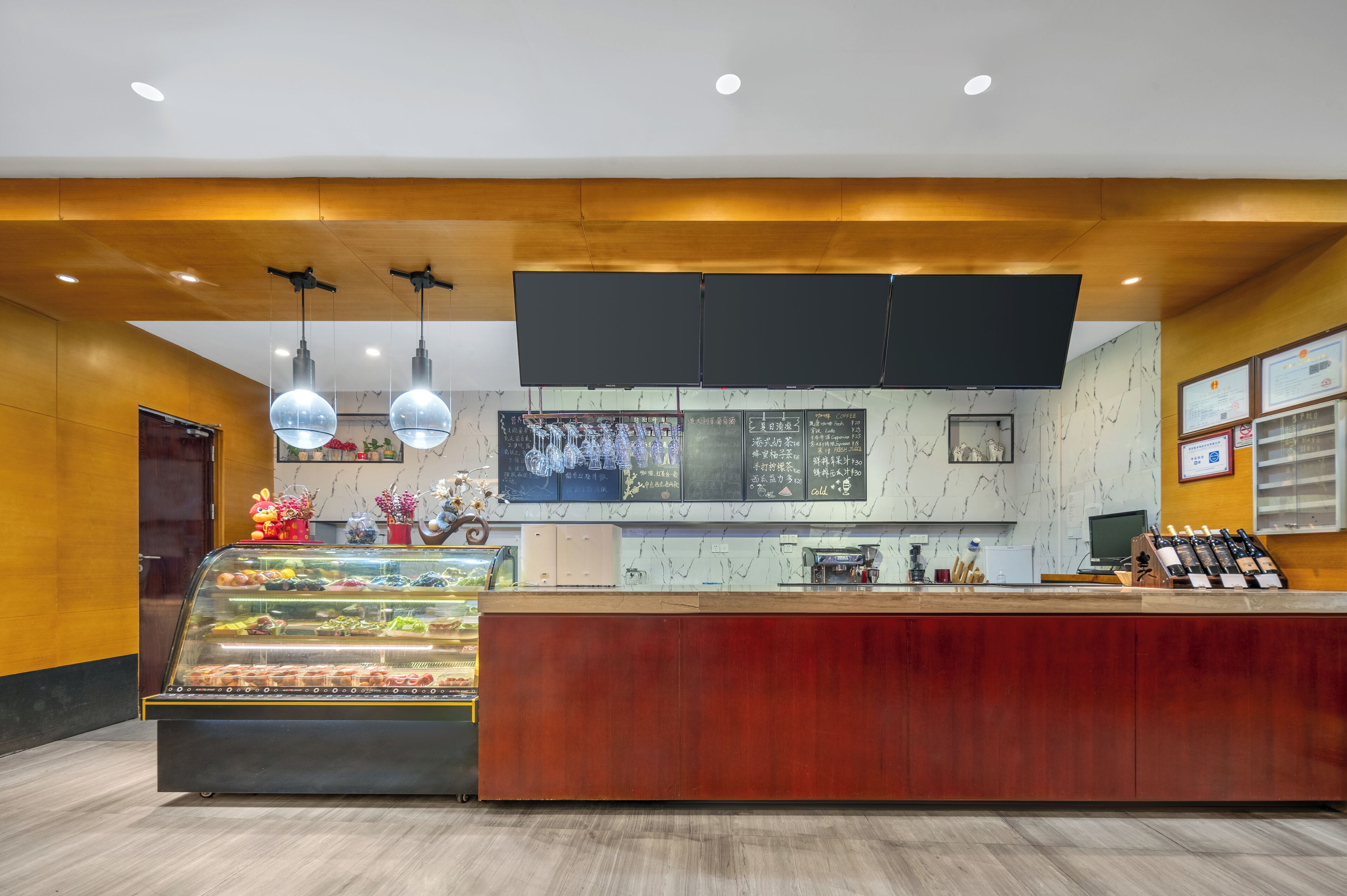 A bakery counter with a display case of pastries, a wooden counter, and a menu board.