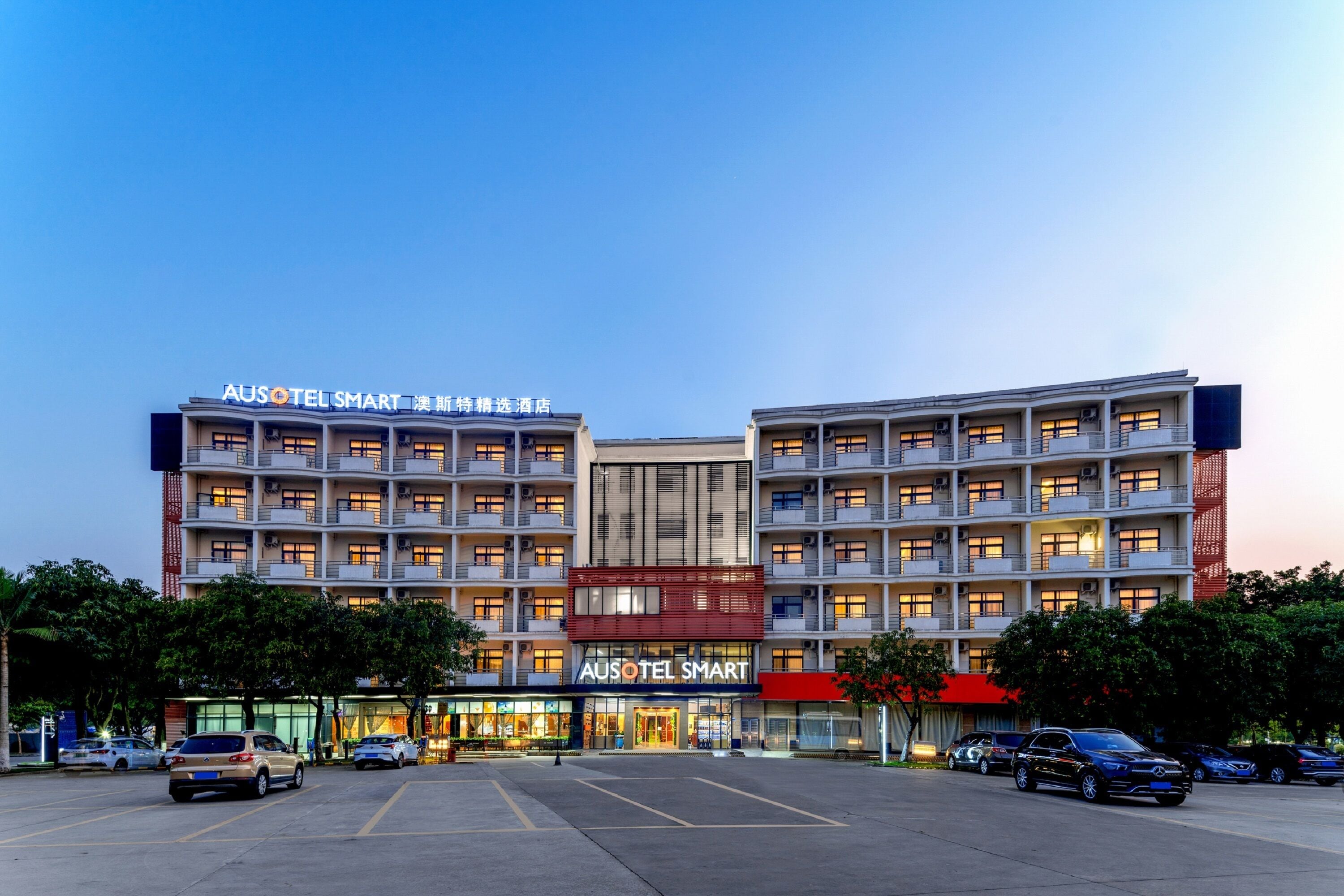 A multi-story hotel with a prominent signage for "AUSOTEL SMART".