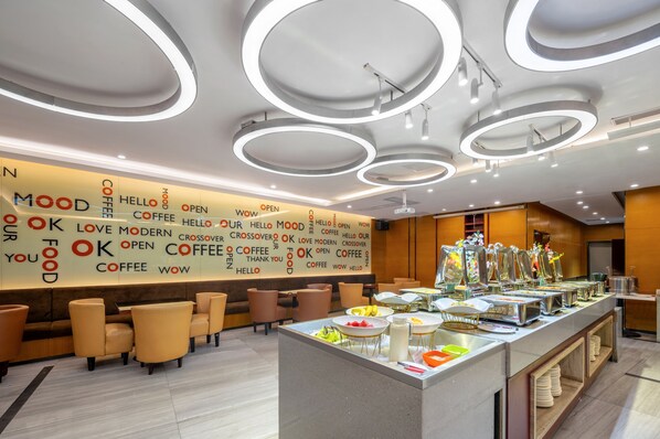 Um café moderno com uma área central de buffet, mesas e cadeiras, e uma parede com a palavra 'Coffee' e 'Open' repetidas.