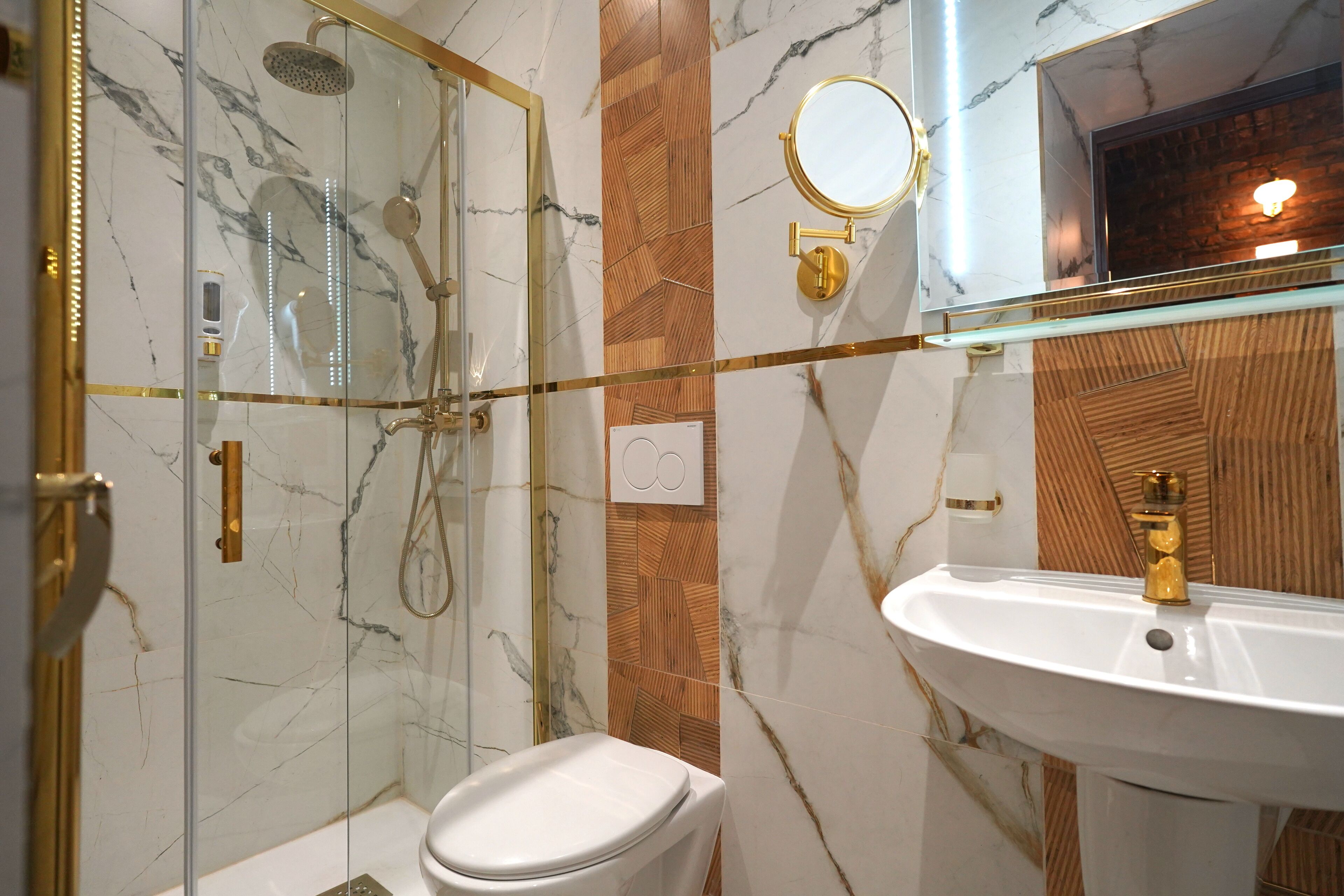 A modern bathroom with a glass-enclosed shower, a white toilet, and a marble-patterned wall.