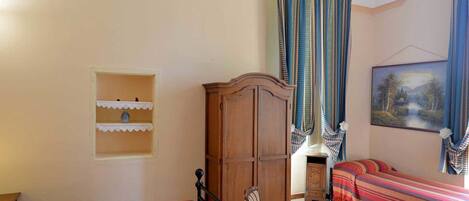 Una habitación con dos camas, un aparador de madera y un cuadro en la pared.