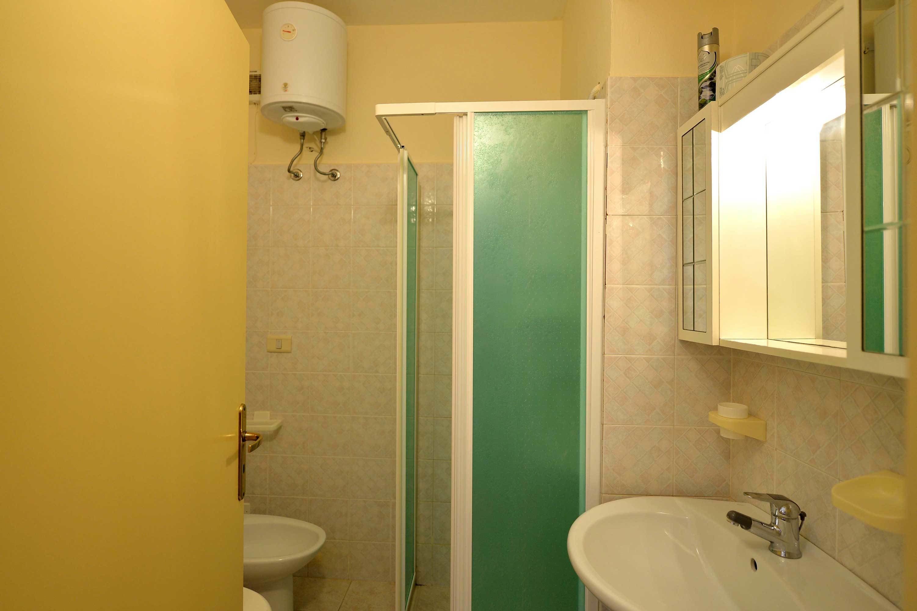 Un baño con inodoro, lavamanos y ducha.