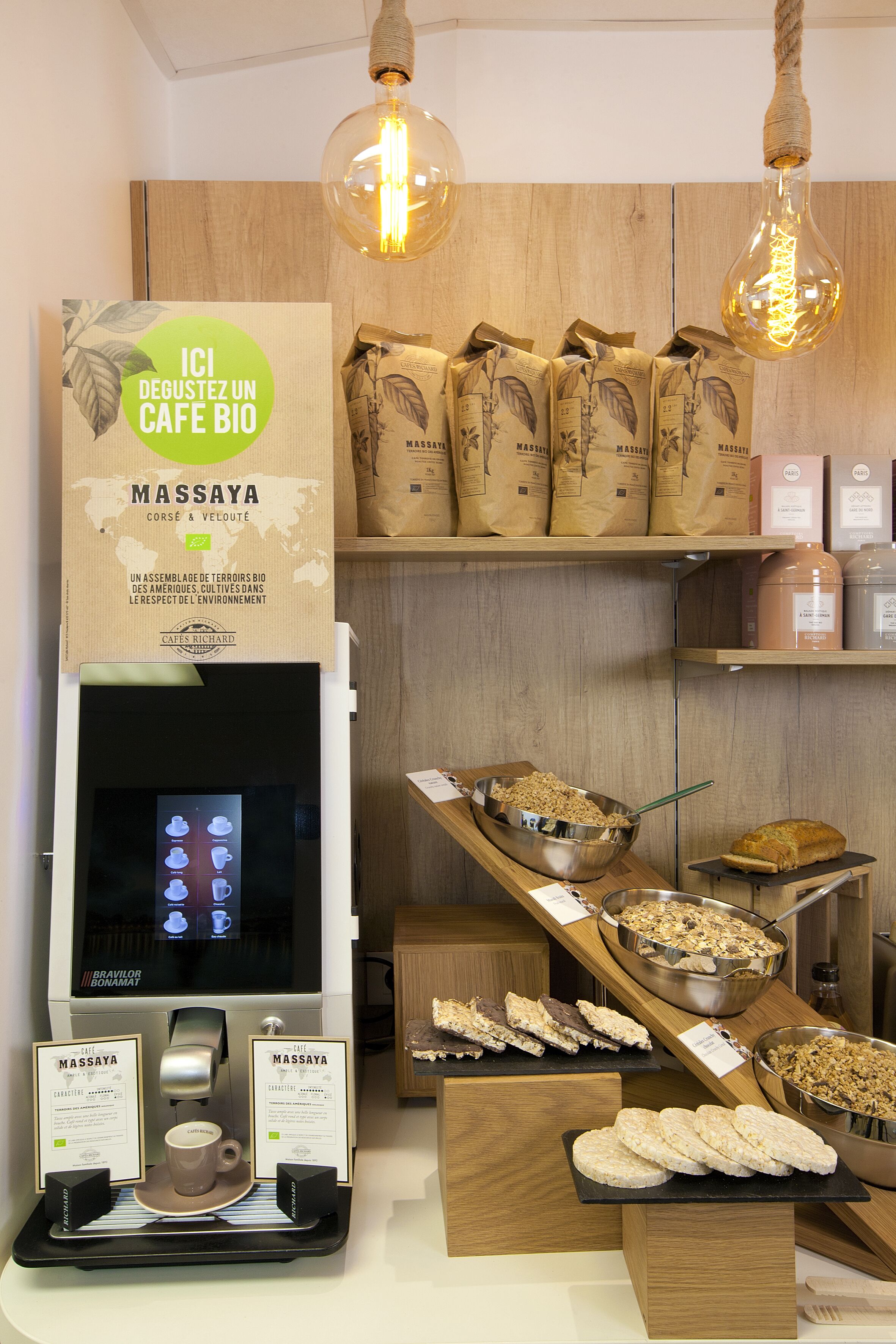 Une vitrine de café présentant une machine à café, des tasses à café et diverses pâtisseries.