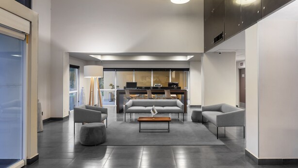 A modern lobby with a central seating area, a reception desk, and a large window providing natural light. - City Express by Marriott Celaya Galerias (Celaya)