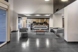 A modern lobby with a central seating area, a reception desk, and a large window providing natural light. - City Express by Marriott Celaya Galerias (Celaya)