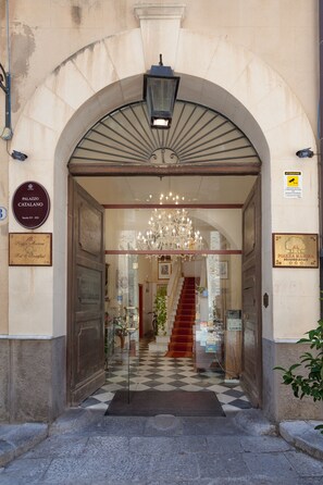 A grand entrance with a checkered floor, a chandelier, and a staircase leading inside. - Al Piazza Marina B&B (Palermo)