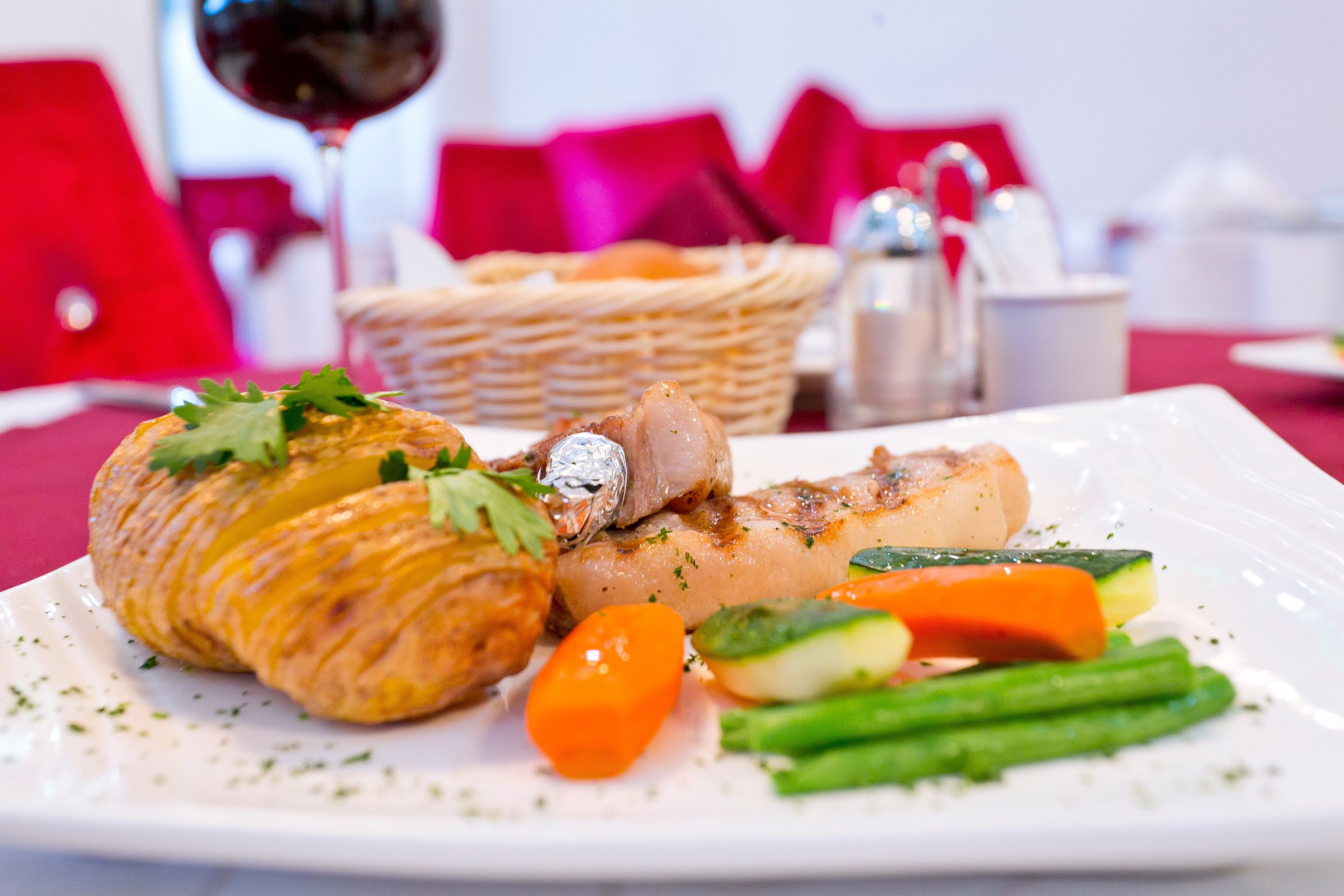 A plate of food with a croissant, meat, and vegetables.