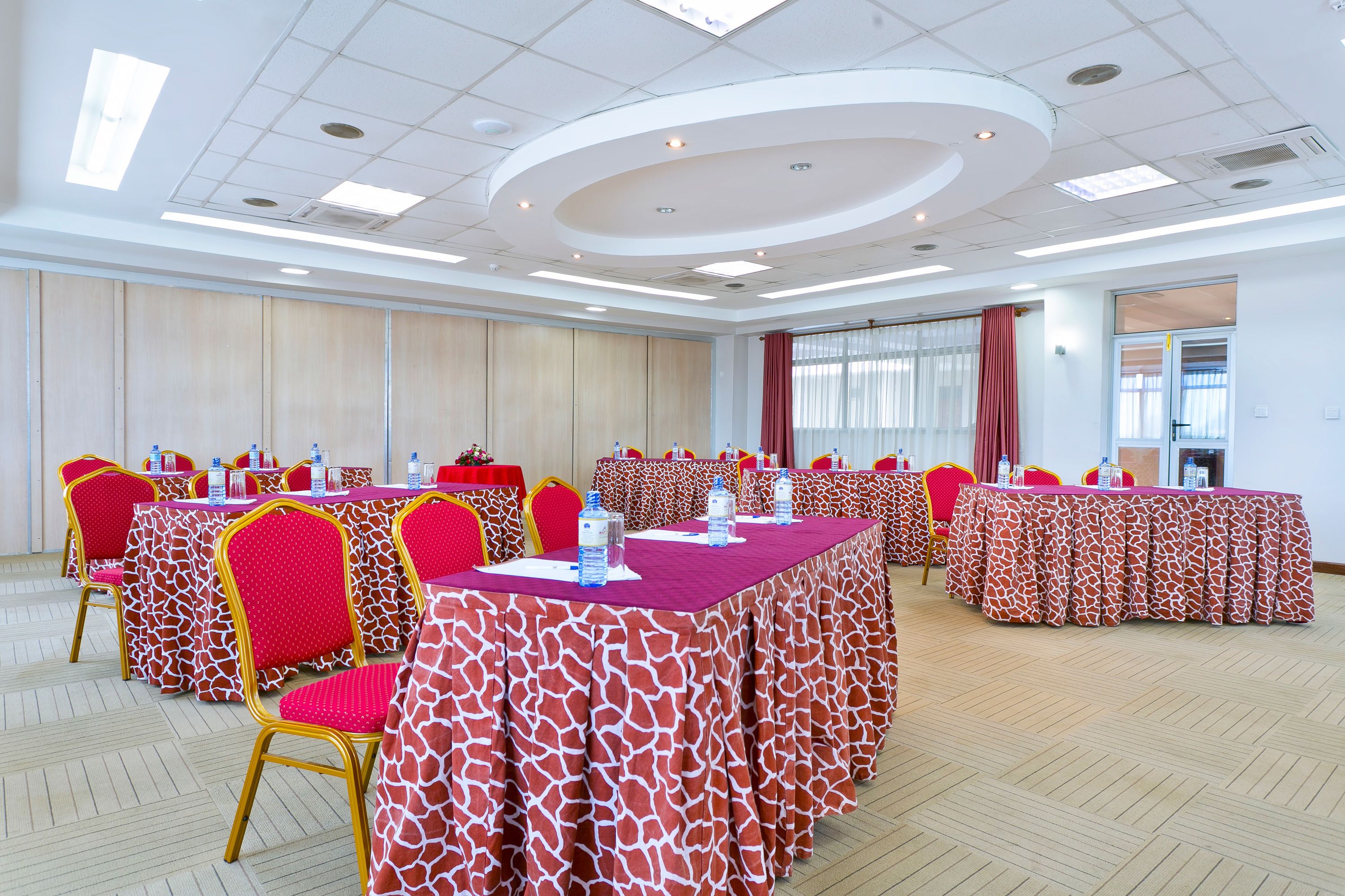 A conference room with multiple tables and chairs, equipped with water bottles and nameplates.