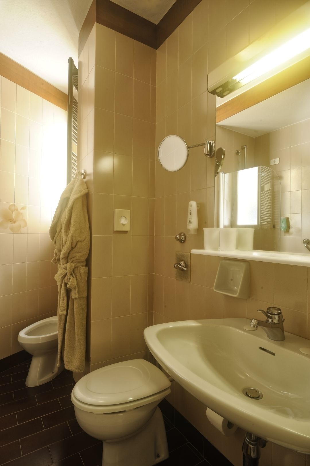 A bathroom with a toilet, a sink, and a mirror.