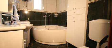 Un baño con bañera, inodoro y lavamanos.