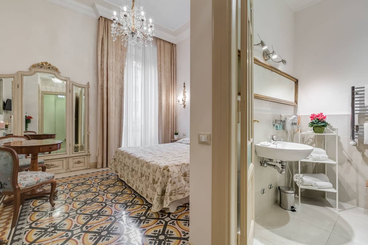 Un dormitorio con cama, cómoda, espejo y candelabro.