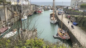 A harbor with boats docked, a pier, and buildings in the background. - The Chapel Guest House (St Austell)