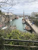 Un puerto con barcos amarrados, un muelle y edificios al fondo.