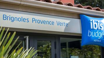 Señal de hotel para Brignoles Provence Verte con una señal contigua del hotel ibis budget.