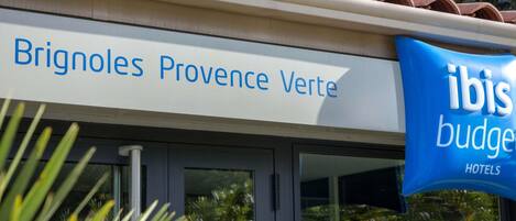 A hotel sign for Brignoles Provence Verte with an adjacent ibis budget hotel sign.
