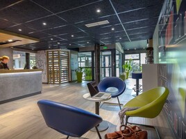Una moderna zona de recepción con mostrador, asientos y vistas al exterior.