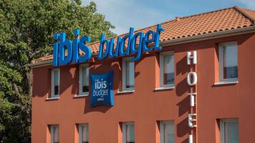 A hotel building with a sign reading 'ibis budget hotels'.