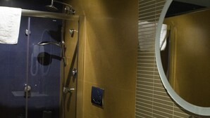 Une salle de bain avec une douche à parois de verre, des toilettes blanches et un lavabo avec un miroir.