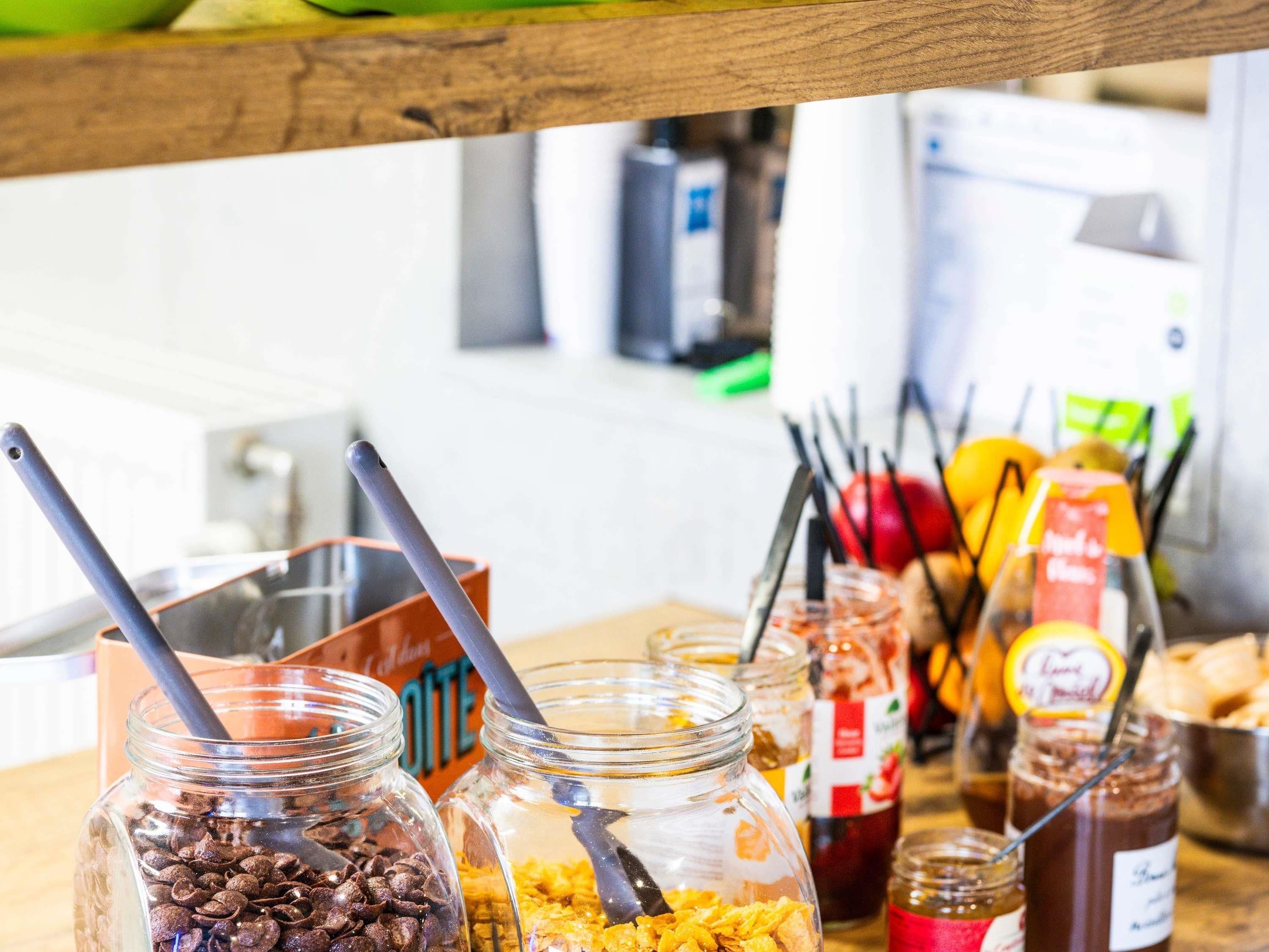 A kitchen counter with jars of food items, a bowl, and a jar of jam.