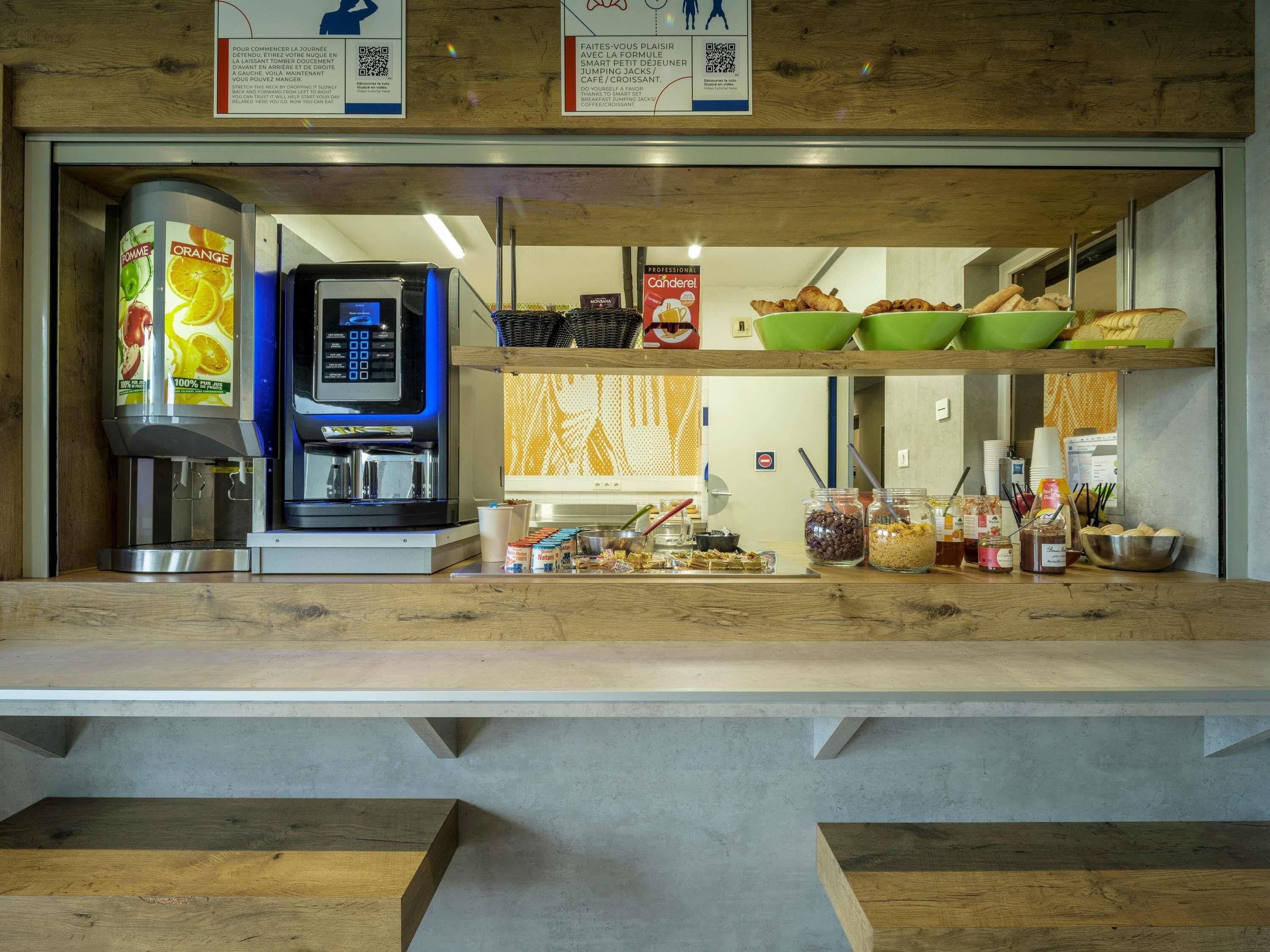 Een ontbijtbuffet met een koffieapparaat, schalen met eten en toevoegingen.