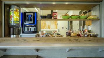 Een ontbijtbuffet met een koffieapparaat, schalen met eten en toevoegingen.