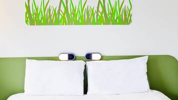 Een bed met witte beddengoed, een groen hoofdbord en twee nachtklokken.