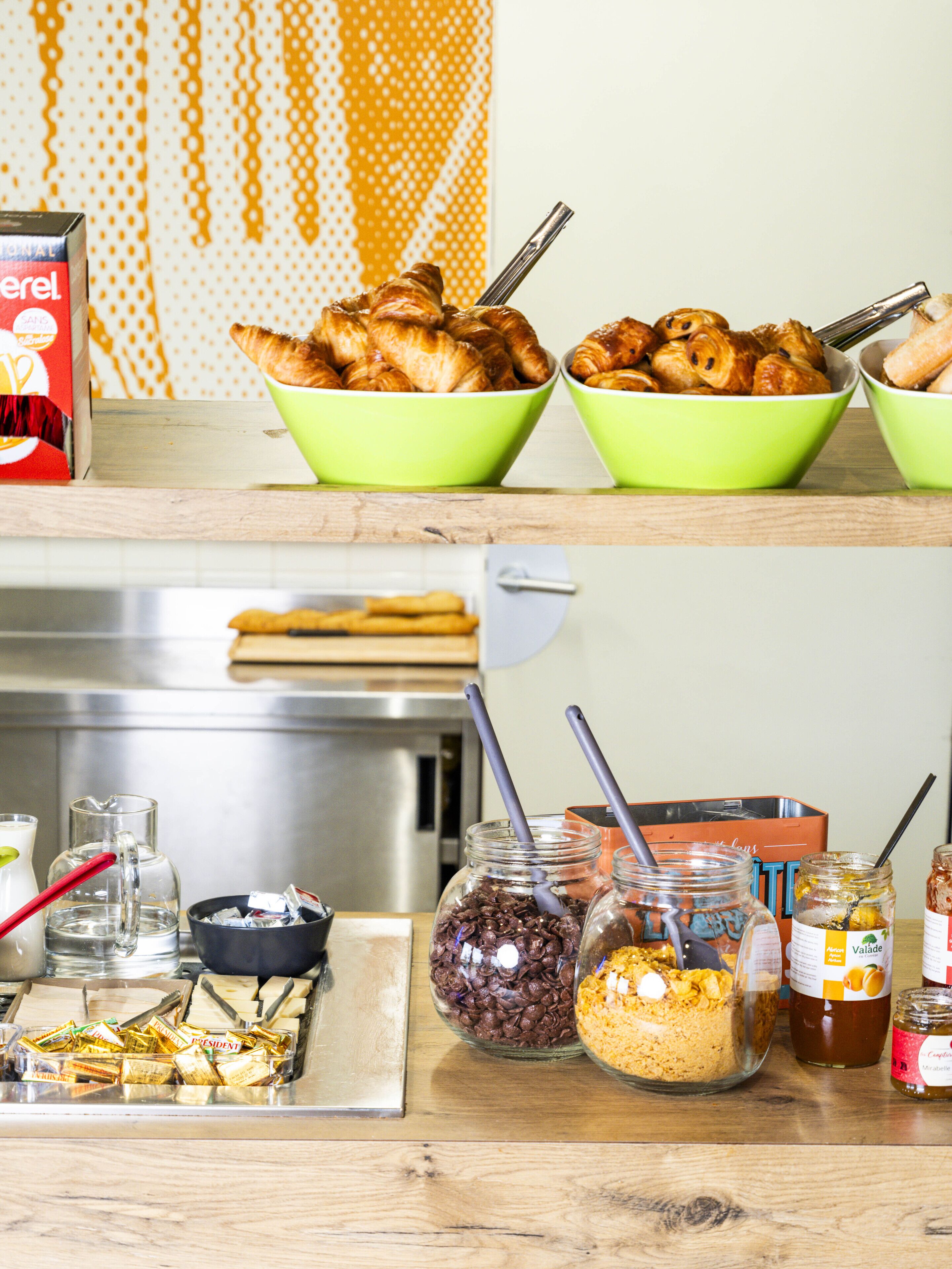 A breakfast buffet with croissants, coffee, and various spreads.
