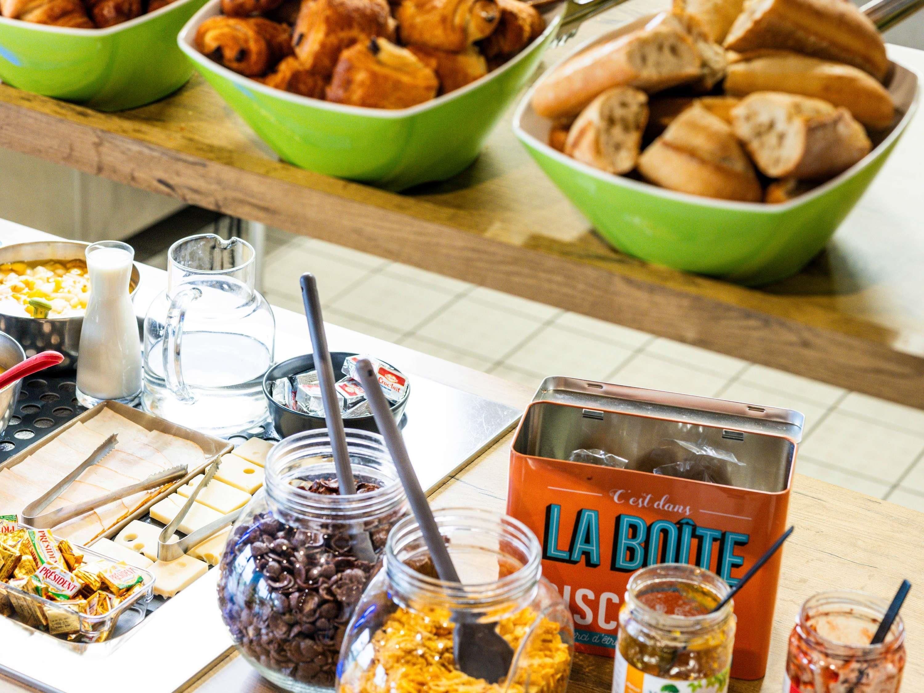 Una mesa de buffet con diversos alimentos y aderezos.