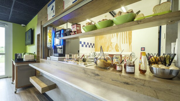 A buffet setup with various food items and condiments on display.