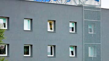 A building with a sign reading 'This Budget Hotels' and multiple windows.