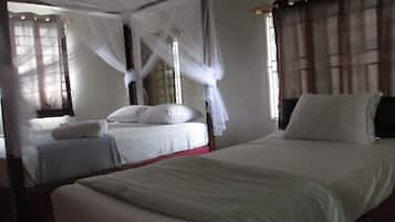 Two beds with white linens and a canopy bed with a white canopy are featured in this traditional room.
