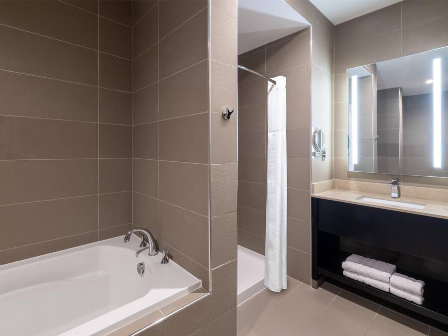 Un baño moderno con bañera, ducha y tocador.
