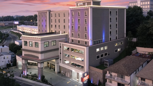 A multi-story hotel with a central courtyard, a parking garage, and a prominent sign indicating it is a Premier hotel.