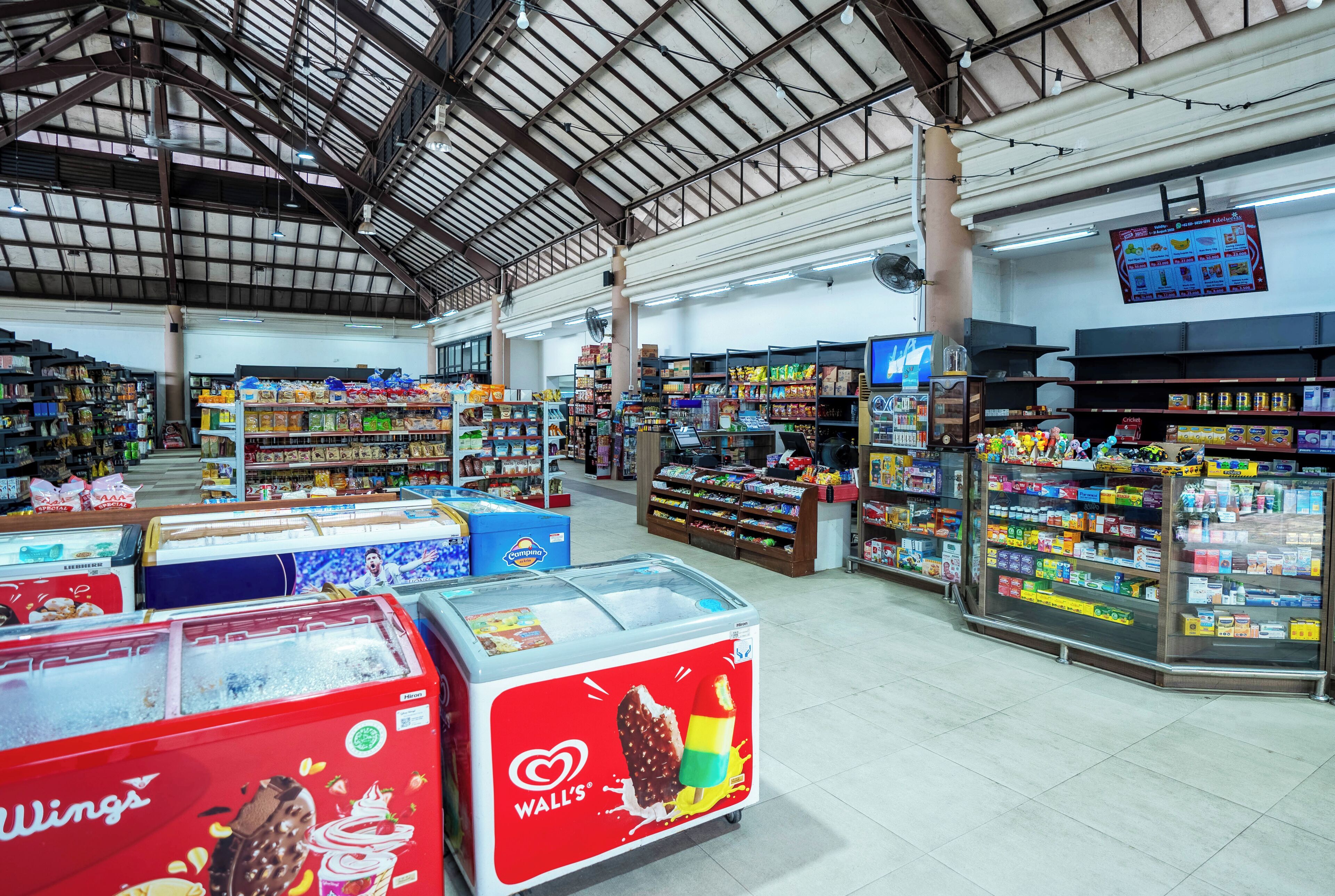 A spacious supermarket with wide aisles and a variety of products on shelves.