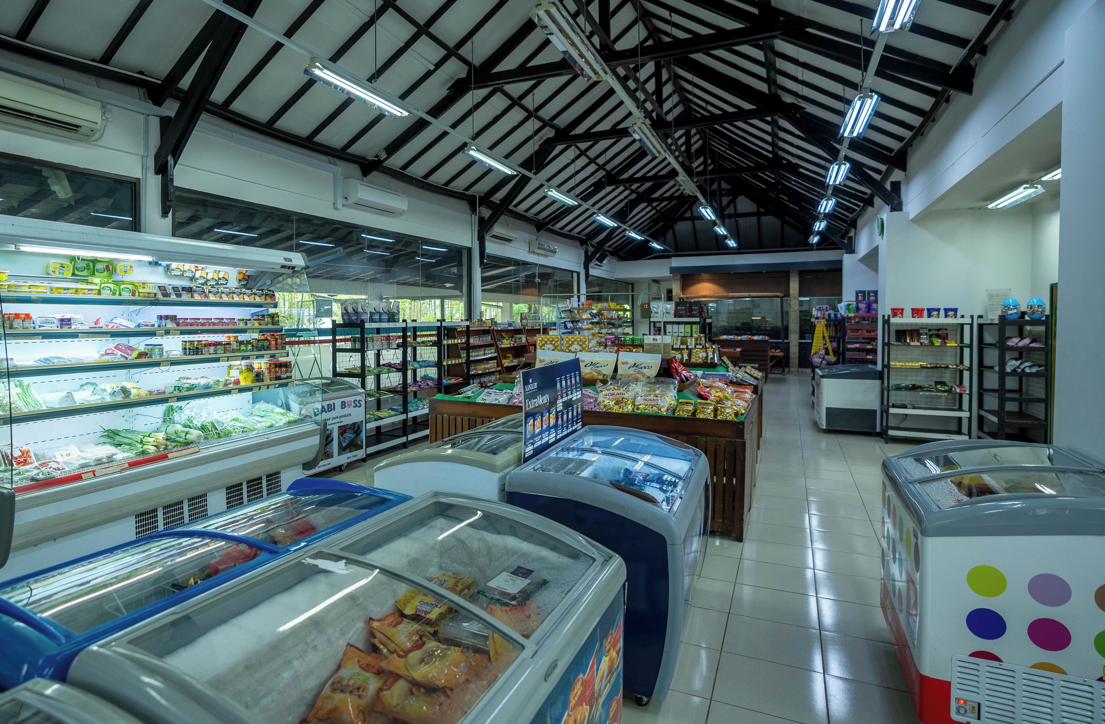 A grocery store interior with refrigerated sections, shelves stocked with various products, and a clean, well-lit environment.