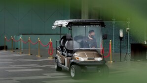 A golf cart parked in a lobby with a red rope barrier and gold stanchions. - Wyndham Panbil Batam (Batam)