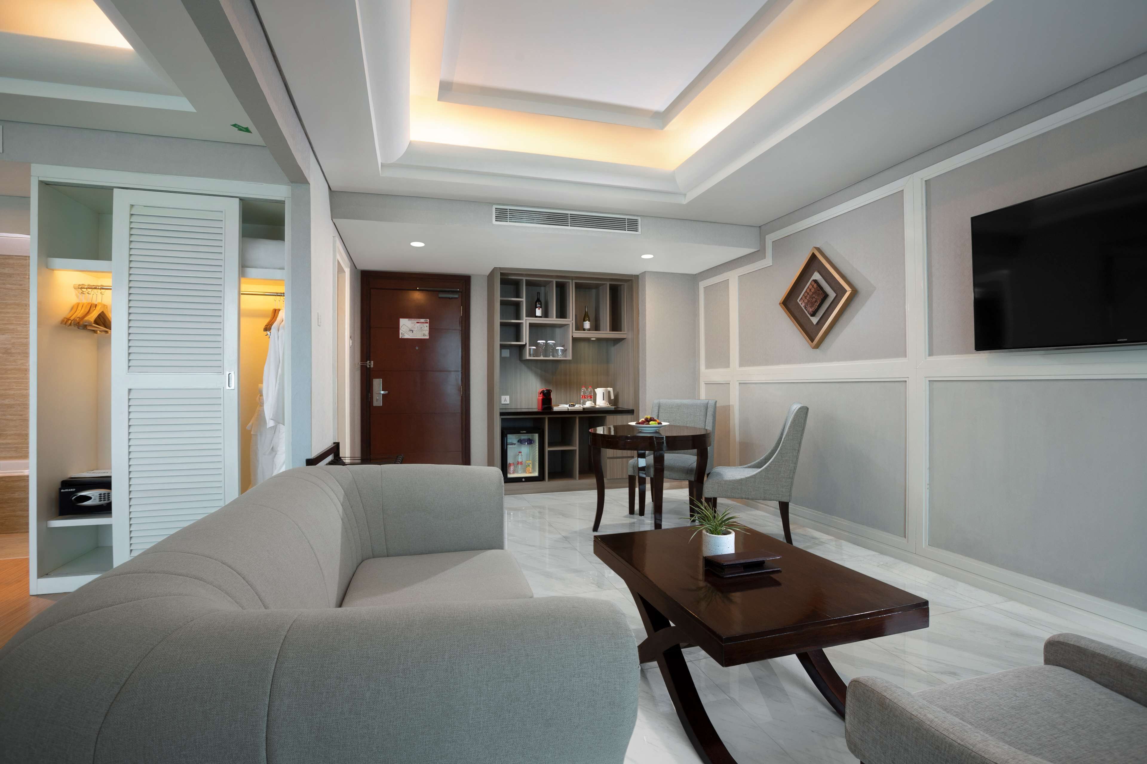 Una sala de estar moderna con un sofá, una mesa de centro, un televisor y un comedor con sillas y una mesa.
