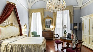 A luxurious bedroom with a four-poster bed, a chandelier, a mirror, and a television. - Residenza d'Epoca Palazzo Borghesi (Siena)